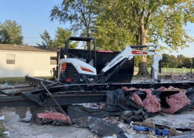 Bobcat mini excavator at a residential demolition site.